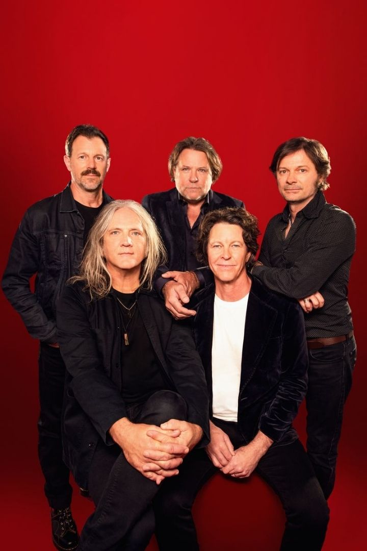 Promotional portrait of Australian rock band Powderfinger against a red studio background. Photo by Giulia Giannini McGauran.